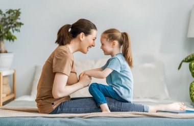 Güzel bir kız bebek ve annesi güneşli bir sabahın tadını çıkarıyorlar. Evde iyi vakit geçir.. 