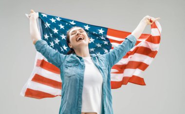 Vatansever bayram. Amerikan bayrağı taşıyan mutlu genç bir kadın. ABD 4 Temmuz 'u kutladı.