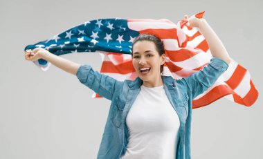 Vatansever bayram. Amerikan bayrağı taşıyan mutlu genç bir kadın. ABD 4 Temmuz 'u kutladı.