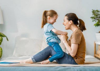 Güzel bir kız bebek ve annesi güneşli bir sabahın tadını çıkarıyorlar. Evde iyi vakit geçir.. 