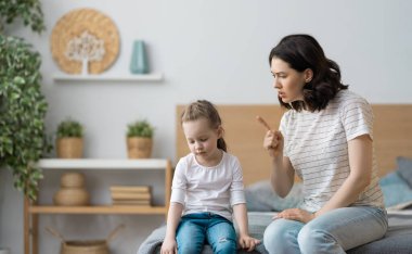 Anne, küçük kızını azarlıyor. aile ilişkileri