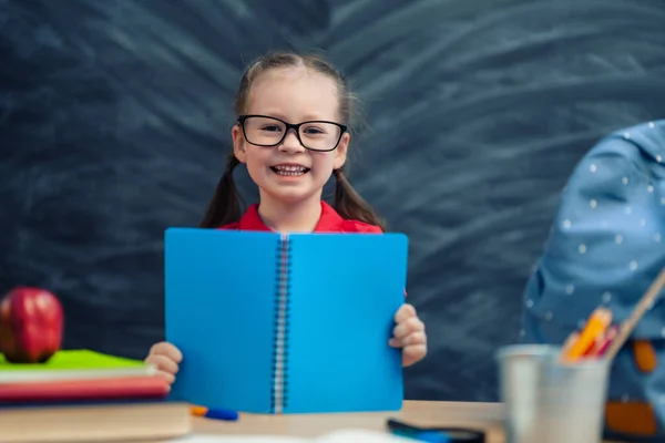 학교로 돌아가 행복하고 귀여운 어린이가 실내에 책상에 아이들은 칠판을 배경으로 — 스톡 사진