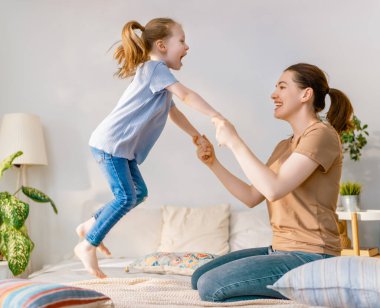 Güzel bir kız bebek ve annesi güneşli bir sabahın tadını çıkarıyorlar. Evde iyi vakit geçir.. 