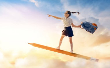 Okula dönün! Mutlu sevimli, çalışkan çocuk günbatımı gökyüzünün arka planında uçuyor. Eğitim ve okuma kavramı. Hayal gücünün gelişimi..