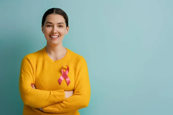 穿着深蓝色背景衣服的年轻女子 粉色丝带就像乳腺癌意识的象征 支助患肿瘤的人 — 图库照片