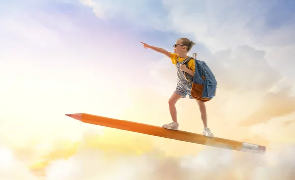 학교로 돌아가 하늘을 배경으로 연필을 날으는 귀엽고도 부지런 어린이는 행복하다 — 스톡 사진