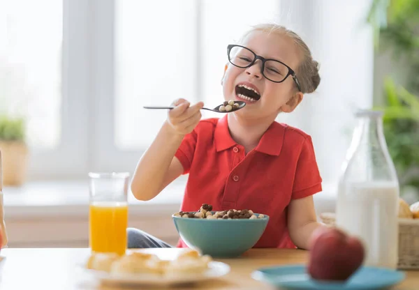 幸せな子供が朝食を食べている キッチンでシリアルを食べる — ストック写真