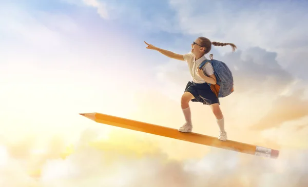 학교로 돌아가 하늘을 배경으로 연필을 날으는 귀엽고도 부지런 어린이는 행복하다 — 스톡 사진