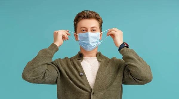 コロナウイルスとインフルエンザの流行の間に顔マスクをしている若い男 ウイルスや病気の保護 家庭の隔離 Covid 2019 マスクの着脱 鉄色の経歴を持つ者 — ストック写真