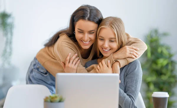 Due Giovani Donne Felici Che Usano Portatile Amici Che Passano — Foto Stock