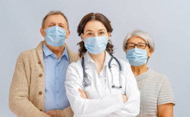 Doktor ve yaşlı çift koronavirüs ve grip salgını sırasında maske takıyor. Virüs koruması, ev karantinası. COVID-2019. Maske takıyor. Beyaz arka plandaki insanlar.
