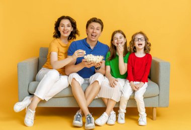 Parlak bir geçmişi olan mutlu ve sevgi dolu bir aile. Baba, anne ve kız TV izleyen kızlar, patlamış mısırlı filmler. Baba, anne ve güzel çocuklar evde kalarak eğleniyorlar..