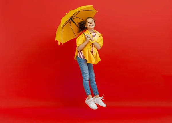 Счастливый Эмоциональный Ребенок Смеется Прыгает Мальчик Желтым Зонтиком Красном Фоне — стоковое фото
