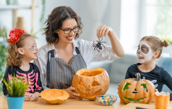 Mutlu aile Cadılar Bayramı için hazırlanıyor. Karnavaldaki anne ve çocuklar evde kostüm giymişler..