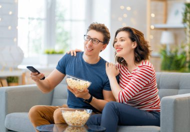 Mutlu aile projektörü, TV, akşam evde patlamış mısırlı filmler. Çiftler birlikte vakit geçiriyorlar..