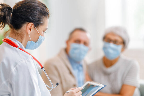 Doctor and senior couple wearing facemasks during coronavirus and flu outbreak. Virus protection, home quarantine. COVID-2019. Taking on masks.