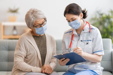 Coronavirus ve grip salgını sırasında maske takan doktor ve son sınıf öğrencisi. Virüs koruması. COVID-2019. Maske takıyor.