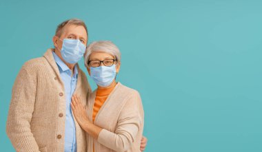 Coronavirus ve grip salgını sırasında yüz maskesi takan yaşlı çift. Virüs ve hastalık koruması, ev karantinası. COVID-2019. Maske takıyor.