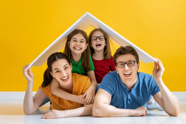 明るい色の背景に屋根のシンボルを持つ母 父と子供の女の子 若い家住宅の概念 — ストック写真