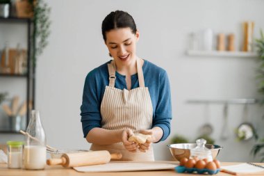 Mutlu kadın fırını hazırlıyor. Kızlar mutfakta kurabiye pişiriyor. Ev yapımı yemek..