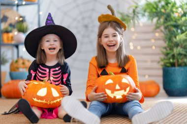  Balkabağı oyan şirin küçük çocuklar. Mutlu aile Cadılar Bayramı için hazırlanıyor. Evdeki komik çocuklar..  