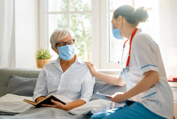 コロナウイルスやインフルエンザの流行中にフェメスクを身に着けている医師や高齢女性 ウイルス対策 Covid 2019 仮面をかぶって — ストック写真