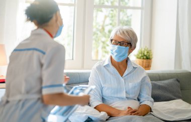 Coronavirus ve grip salgını sırasında maske takan doktor ve son sınıf öğrencisi. Virüs koruması. COVID-2019. Maske takıyor.