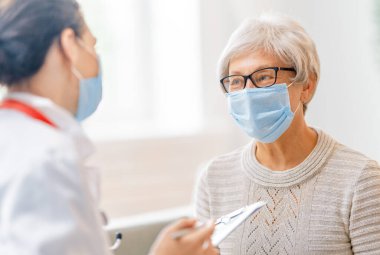Coronavirus ve grip salgını sırasında maske takan doktor ve son sınıf öğrencisi. Virüs koruması. COVID-2019. Maske takıyor.