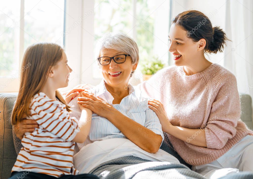 A nice girl, her mother and grandmother enjoying spending time together at home. 