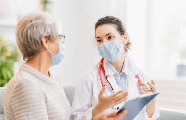 Coronavirus ve grip salgını sırasında maske takan doktor ve son sınıf öğrencisi. Virüs koruması. COVID-2019. Maske takıyor.