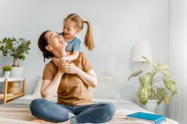 Güzel bir kız bebek ve annesi güneşli bir sabahın tadını çıkarıyorlar. Evde iyi vakit geçir.. 