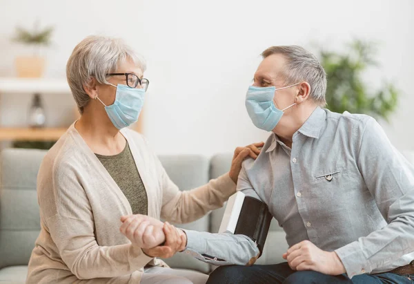 顔のマスクを着用し コロナウイルスやインフルエンザ発生時の血圧を測定するシニアカップル ウイルスや病気の保護 家庭の隔離 Covid 2019 — ストック写真