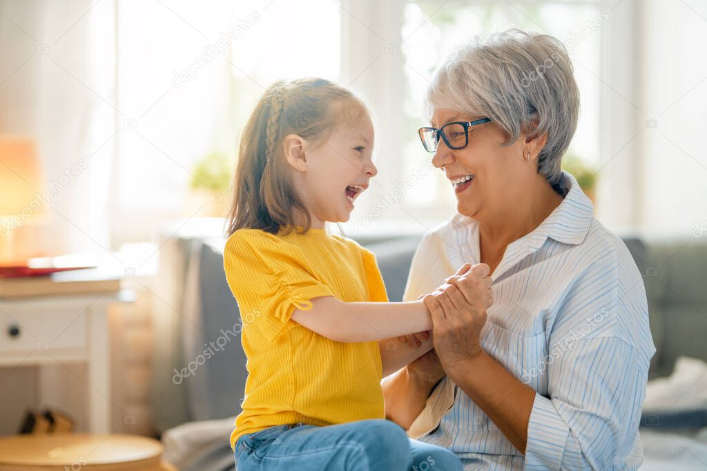 A nice girl and her grandmother enjoying sunny morning. Good time at home. 