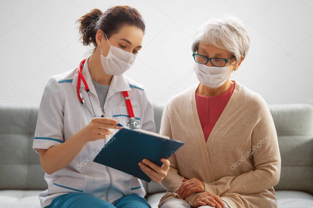 Doctor and senior woman wearing facemasks during coronavirus and flu outbreak. Virus protection. COVID-2019. Taking on masks.