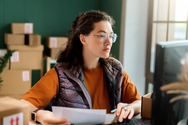Kadın envanter müdürü stokları kontrol ediyor. Depoda çalışan bir kadın.. 