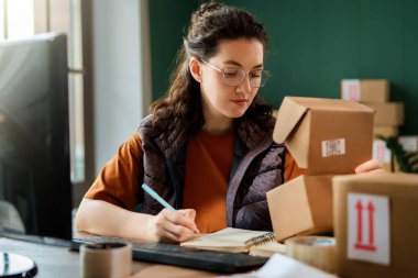 Kadın envanter müdürü stokları kontrol ediyor. Depoda çalışan bir kadın.. 