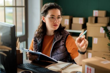 Kadın envanter müdürü stokları kontrol ediyor. Depoda çalışan bir kadın.. 