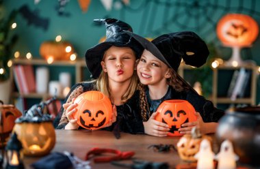 Cadı kostümlü iki kız Cadılar Bayramı 'nı kutluyor. Balkabaklı çocuklar