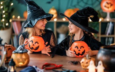 Cadı kostümlü iki kız Cadılar Bayramı 'nı kutluyor. Balkabaklı çocuklar