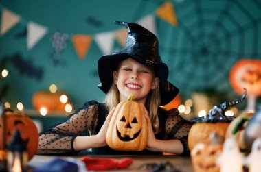 Cadı kostümlü kız Cadılar Bayramı 'nı kutluyor. Balkabaklı çocuk.