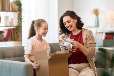 Anne ve kızı karton kutuları boşaltıyorlar. Çevrimiçi alışveriş kavramı.