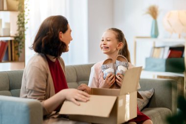 Anne ve kızı karton kutuları boşaltıyorlar. Çevrimiçi alışveriş kavramı.