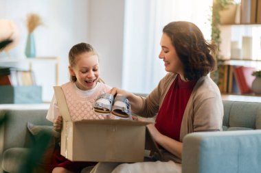 Anne ve kızı karton kutuları boşaltıyorlar. Çevrimiçi alışveriş kavramı.