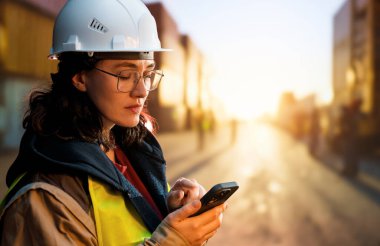 Beyaz şapkalı kadın endüstriyel mühendis konteyner terminalinde çalışıyor..