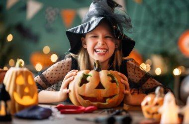 Cadı kostümlü kız Cadılar Bayramı 'nı kutluyor. Balkabaklı çocuk.