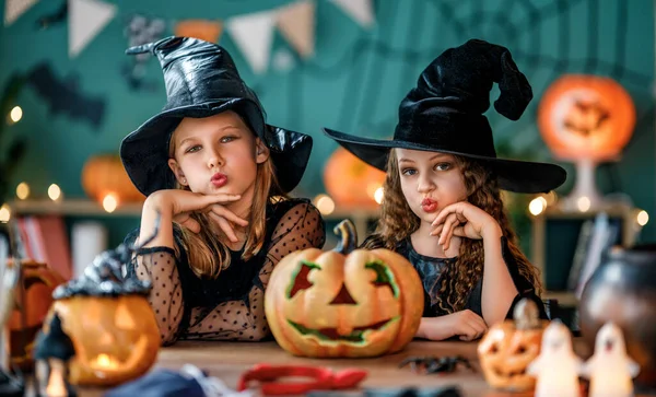 Cadı kostümlü iki kız Cadılar Bayramı 'nı kutluyor. Balkabaklı çocuklar