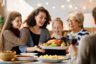 Şükran Günü, Sonbahar ziyafeti. Masada oturup bayramı kutlayan mutlu bir aile. Geleneksel yemek. Büyükanne ve torunlar..   