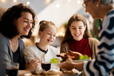 Şükran Günü, Sonbahar ziyafeti. Masada oturup bayramı kutlayan mutlu bir aile. Geleneksel yemek. Büyükanne ve torunlar..   