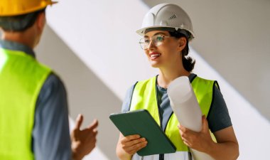 İnşaat alanında planlar üzerinde çalışan mimarlardan oluşan bir ekip..