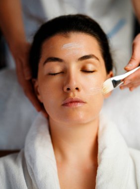 Kaplıca salonunda yüz bakımı. Cilt bakımı ve masaj. Kozmetik uzmanı çalışıyor.